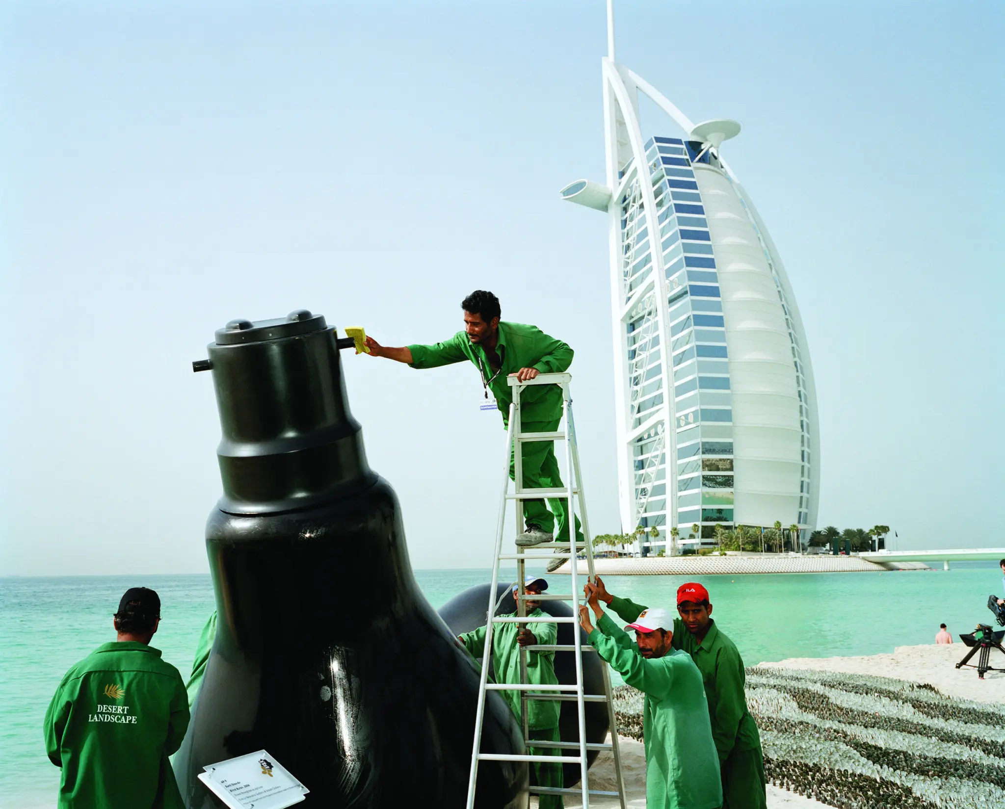 Visitors moving through an Art Dubai fair hall with large-scale photographic work on display.