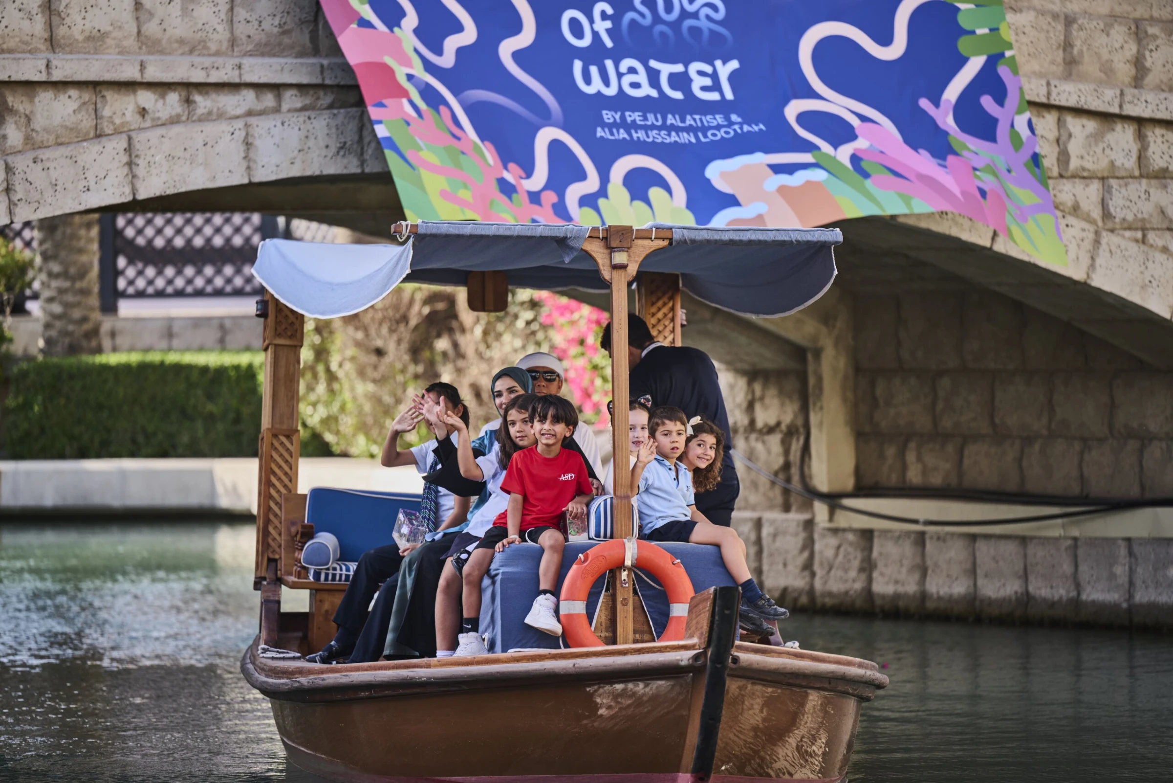 Visitors walking through Art Dubai fair aisles lined with gallery booths and large contemporary works.