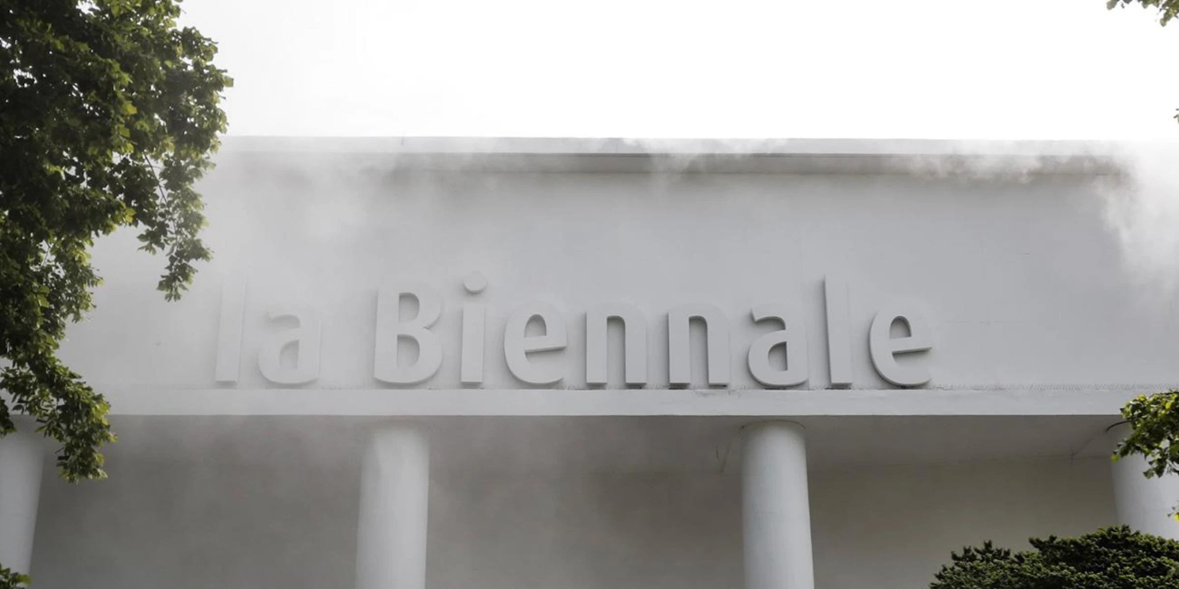 Visitors and signage at the Venice Biennale grounds.