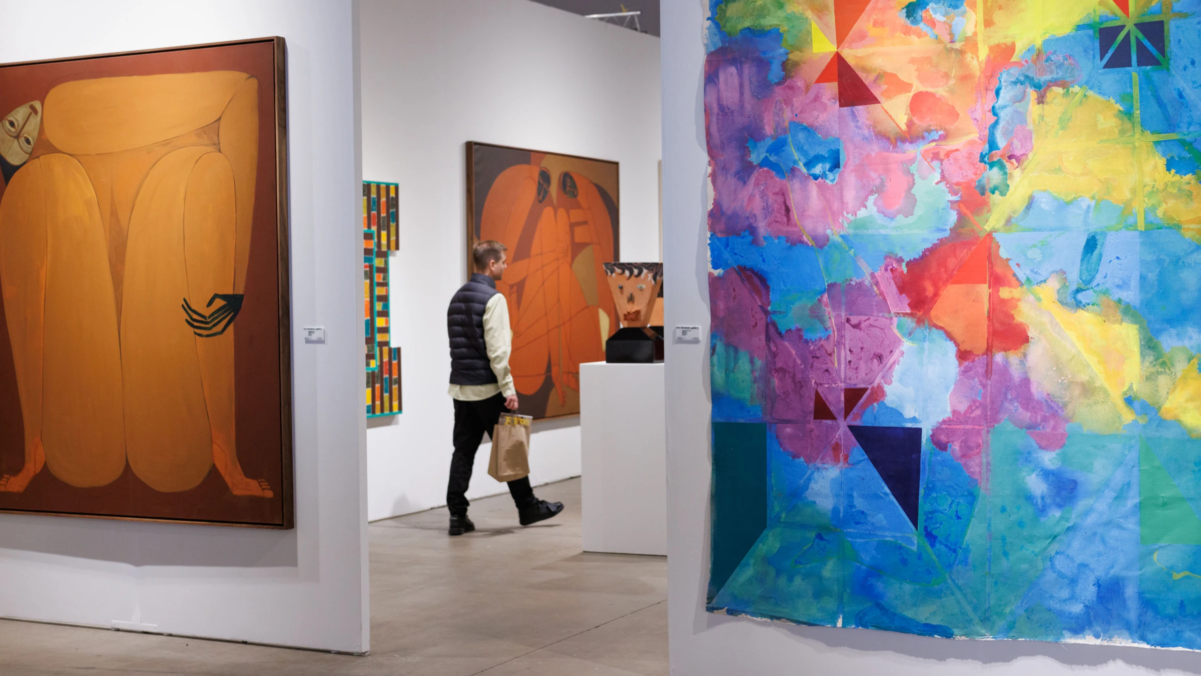 Crowded aisle and booth presentations at Expo Chicago, with collectors reviewing works on view.