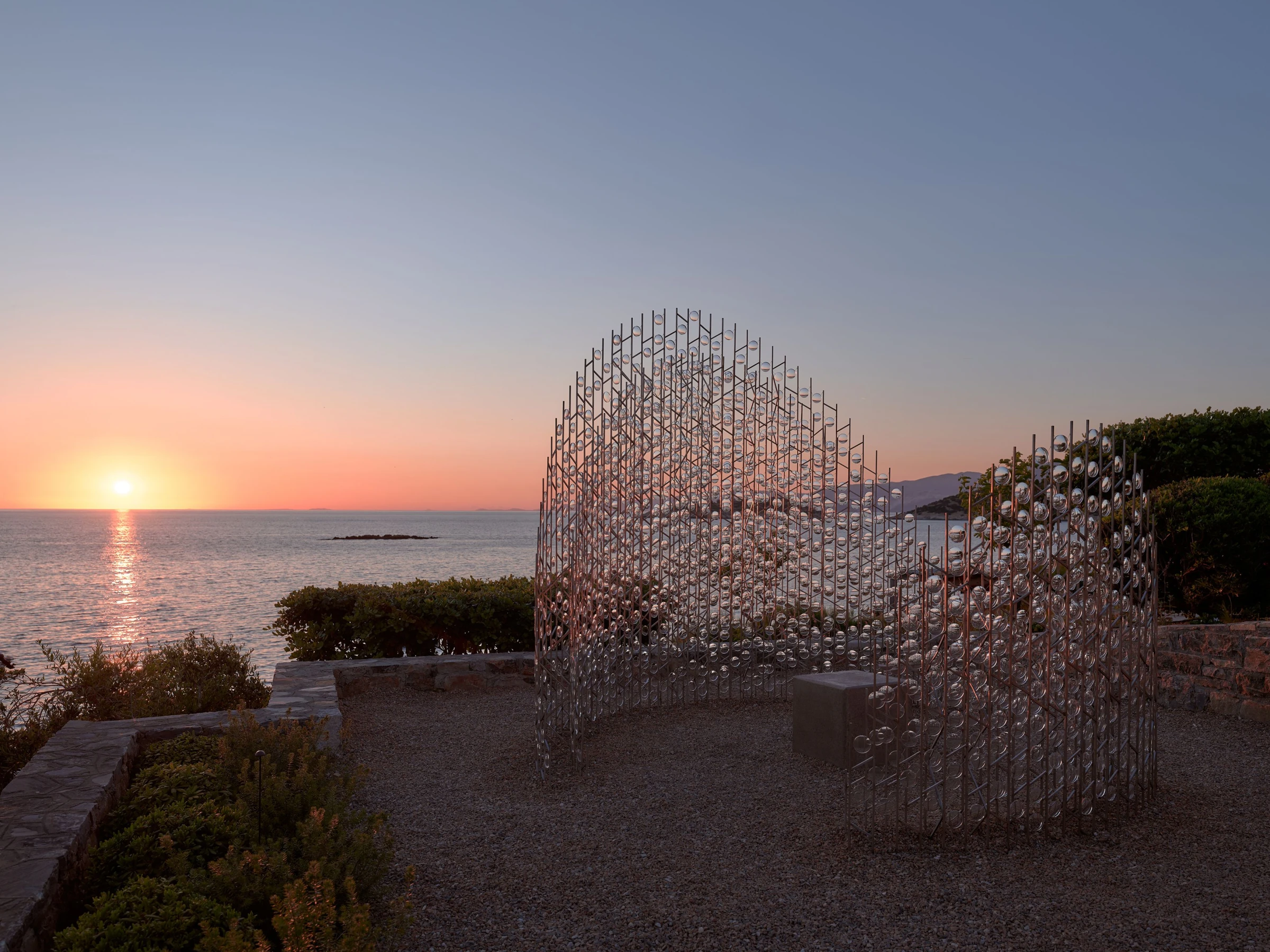 Chronotopia installation by Caitlind R.C. Brown and Wayne Garrett at the Minos Palace Resort in Crete, made from hundreds of unused eyeglass lenses that catch the Mediterranean light and shatter the horizon into miniature worlds