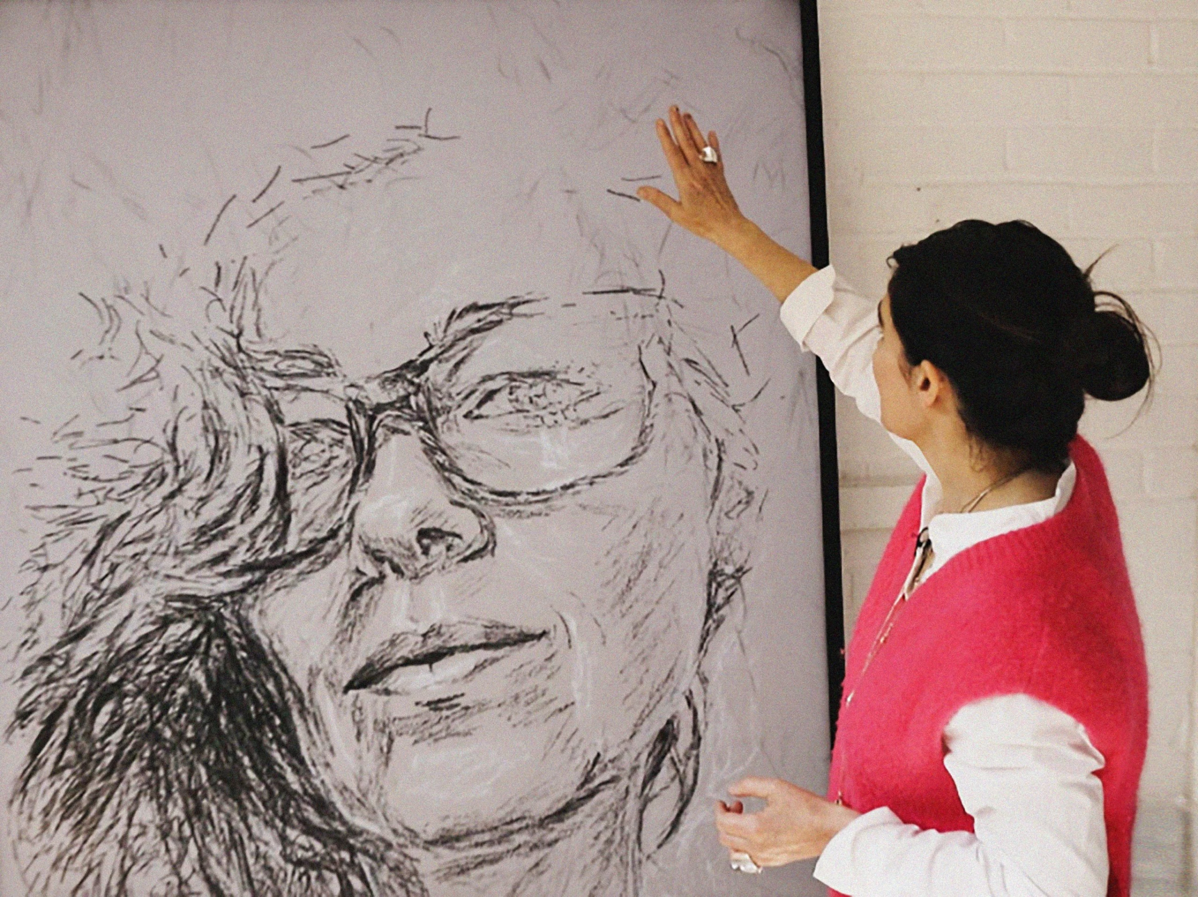 Es Devlin in her studio considering a digital portrait created during testing for A National Portrait.