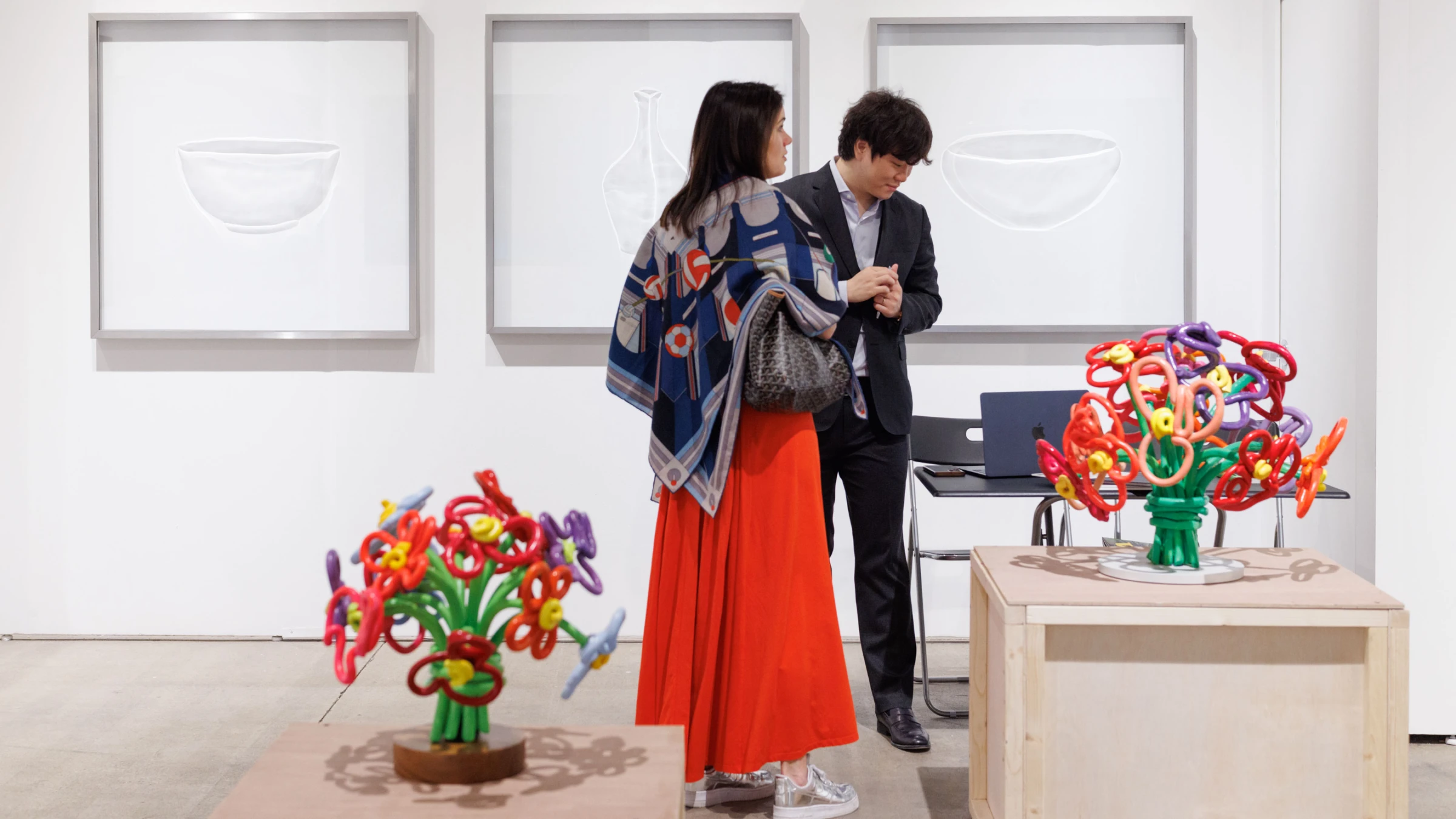 Visitors viewing large-scale presentations on the Expo Chicago fair floor at Navy Pier.