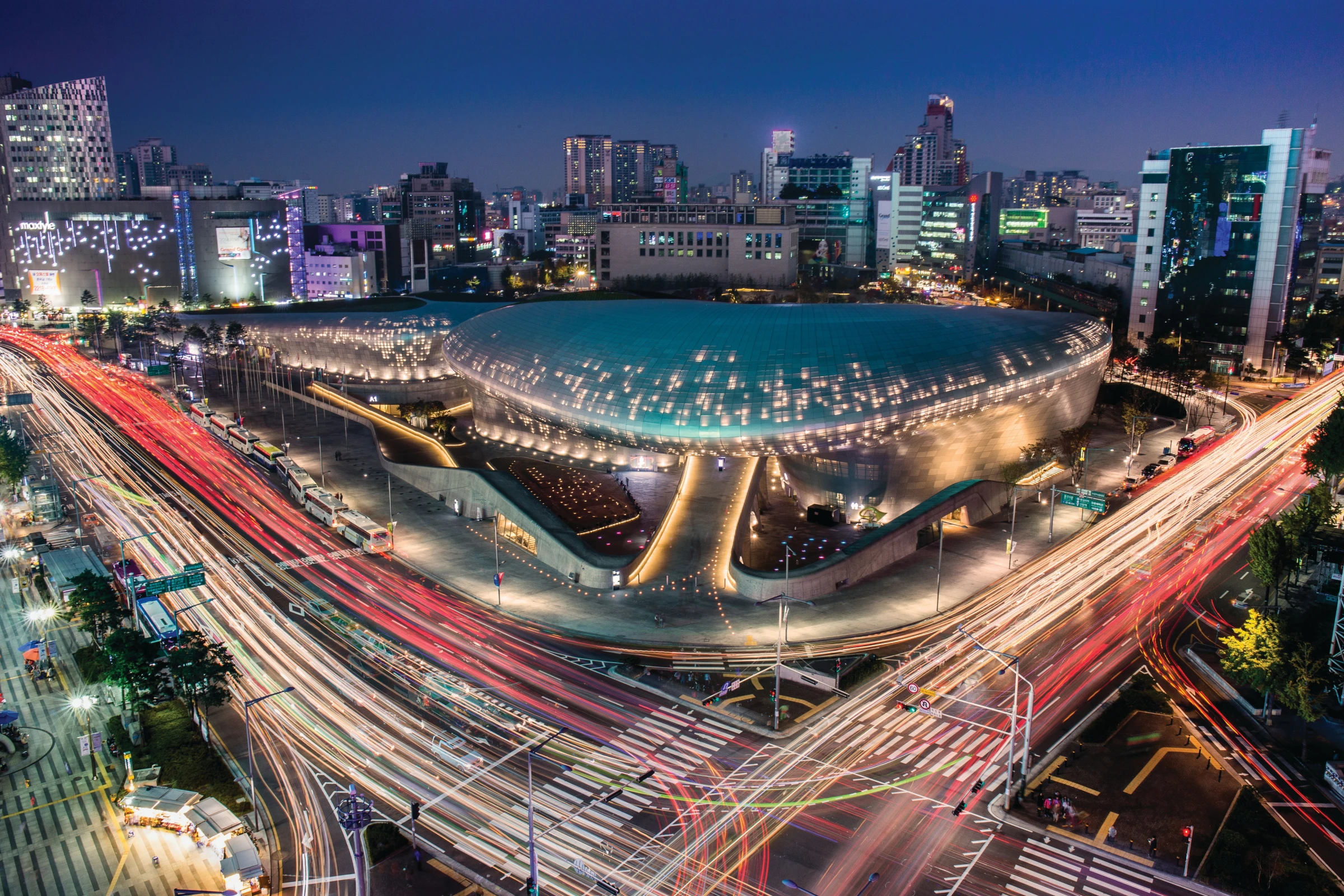 Dongdaemun Design Plaza, a curving aluminium-clad cultural centre designed by Zaha Hadid, photographed from above showing its distinctive flowing forms