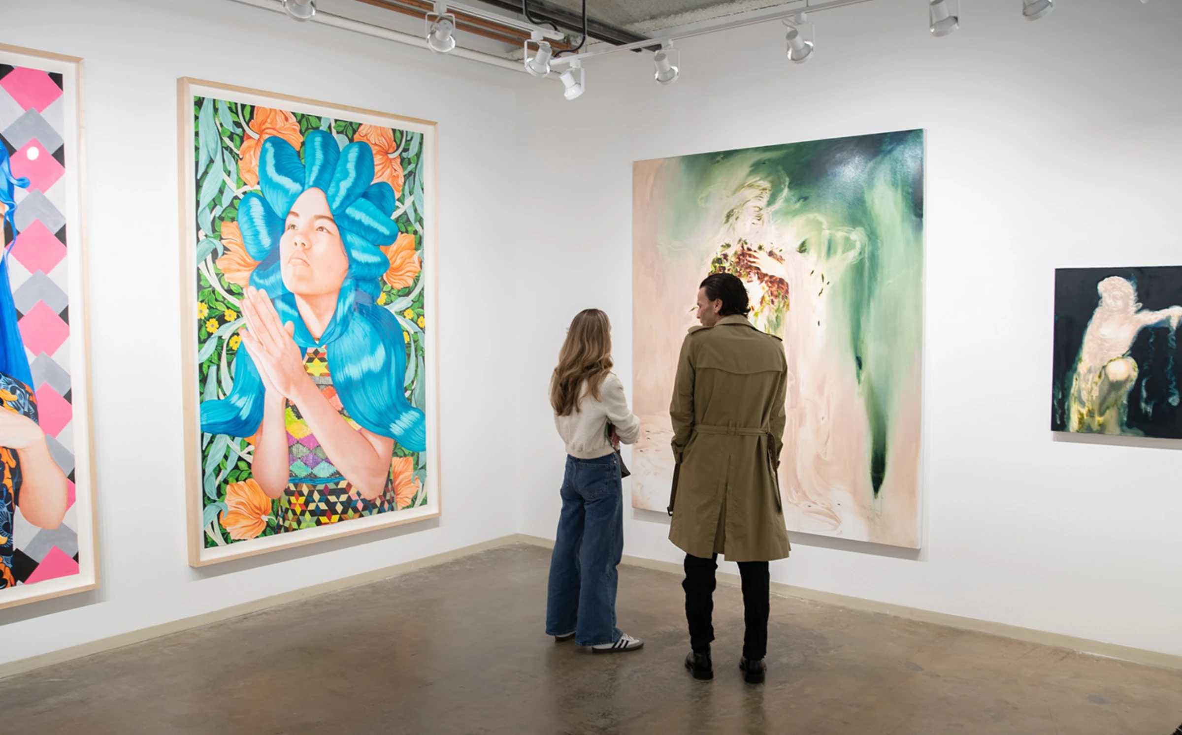 Collectors and curators viewing booths at a regional art fair while discussing works