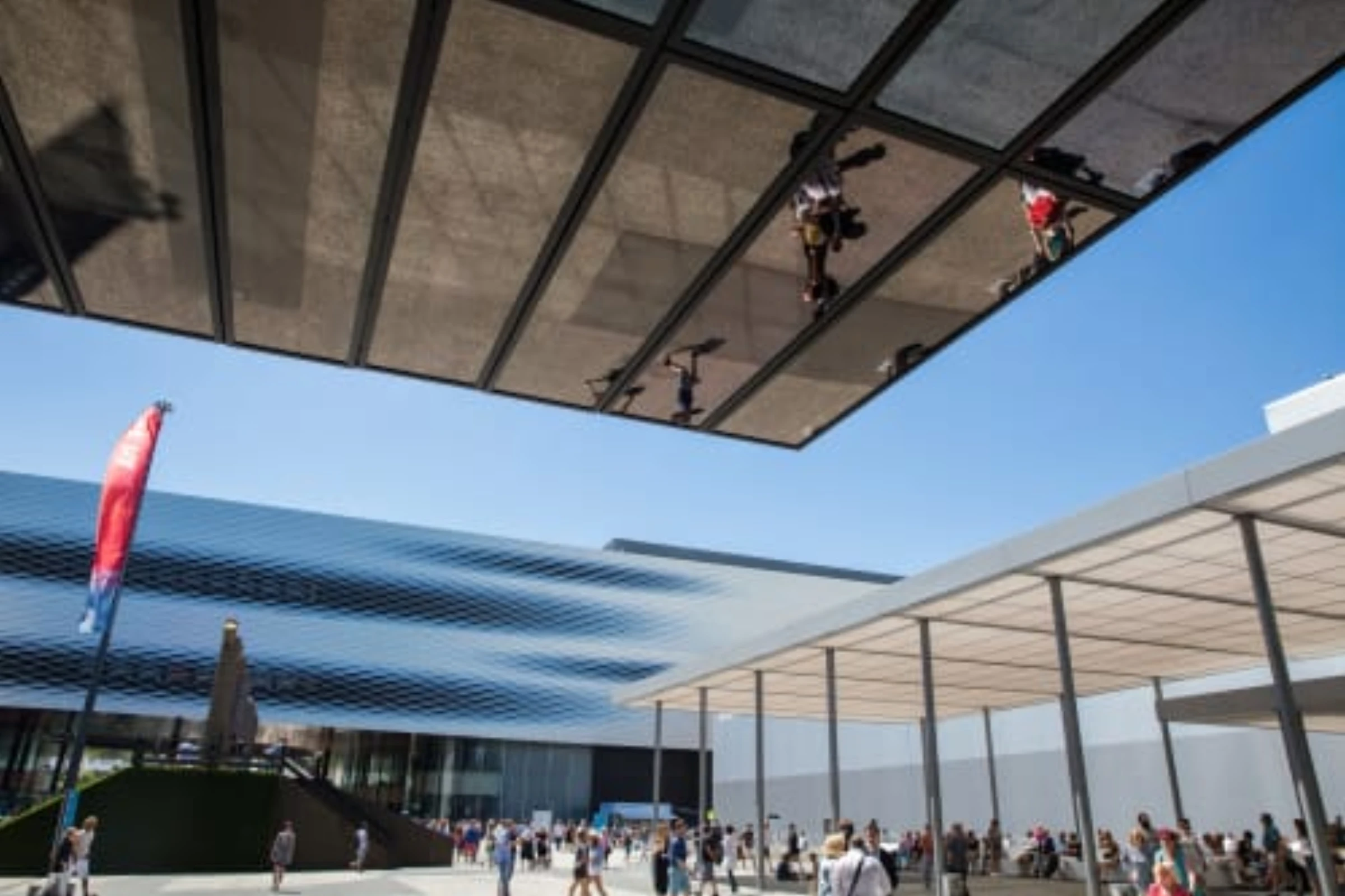 Visitors walking through an Art Basel fair hall with large-scale installations