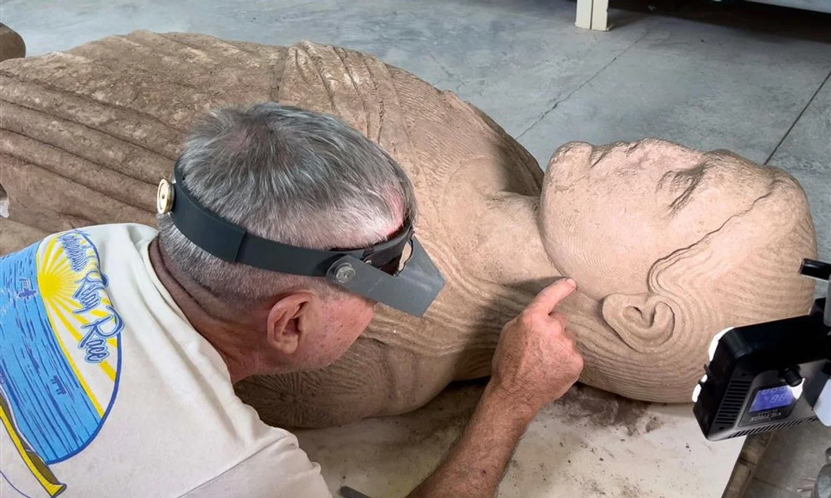 The 2,500-year-old colossal statue of a young man holding fruit, excavated in two pieces at the ancient city of Sardis in Turkey
