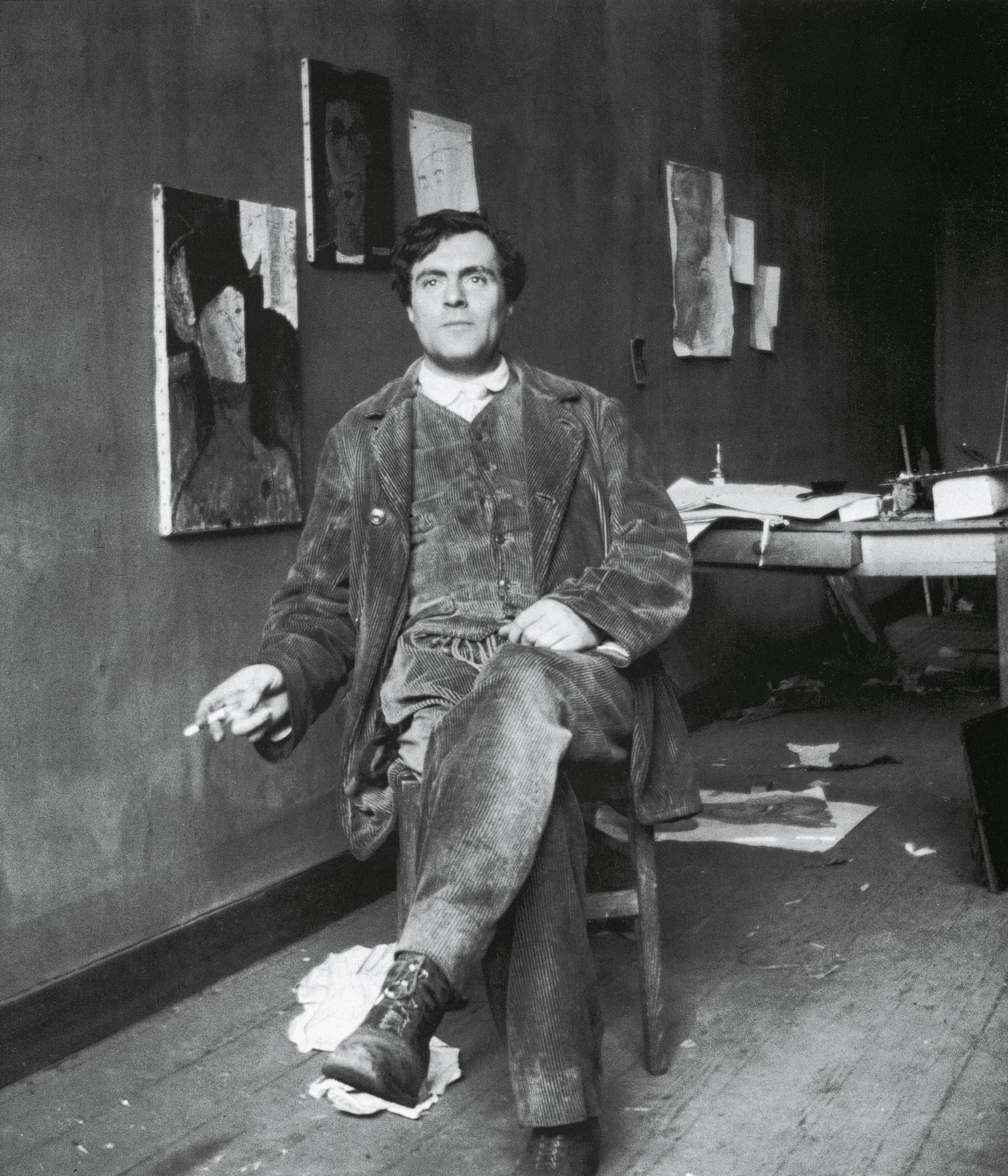 Amedeo Modigliani in his studio, seated and facing the camera.