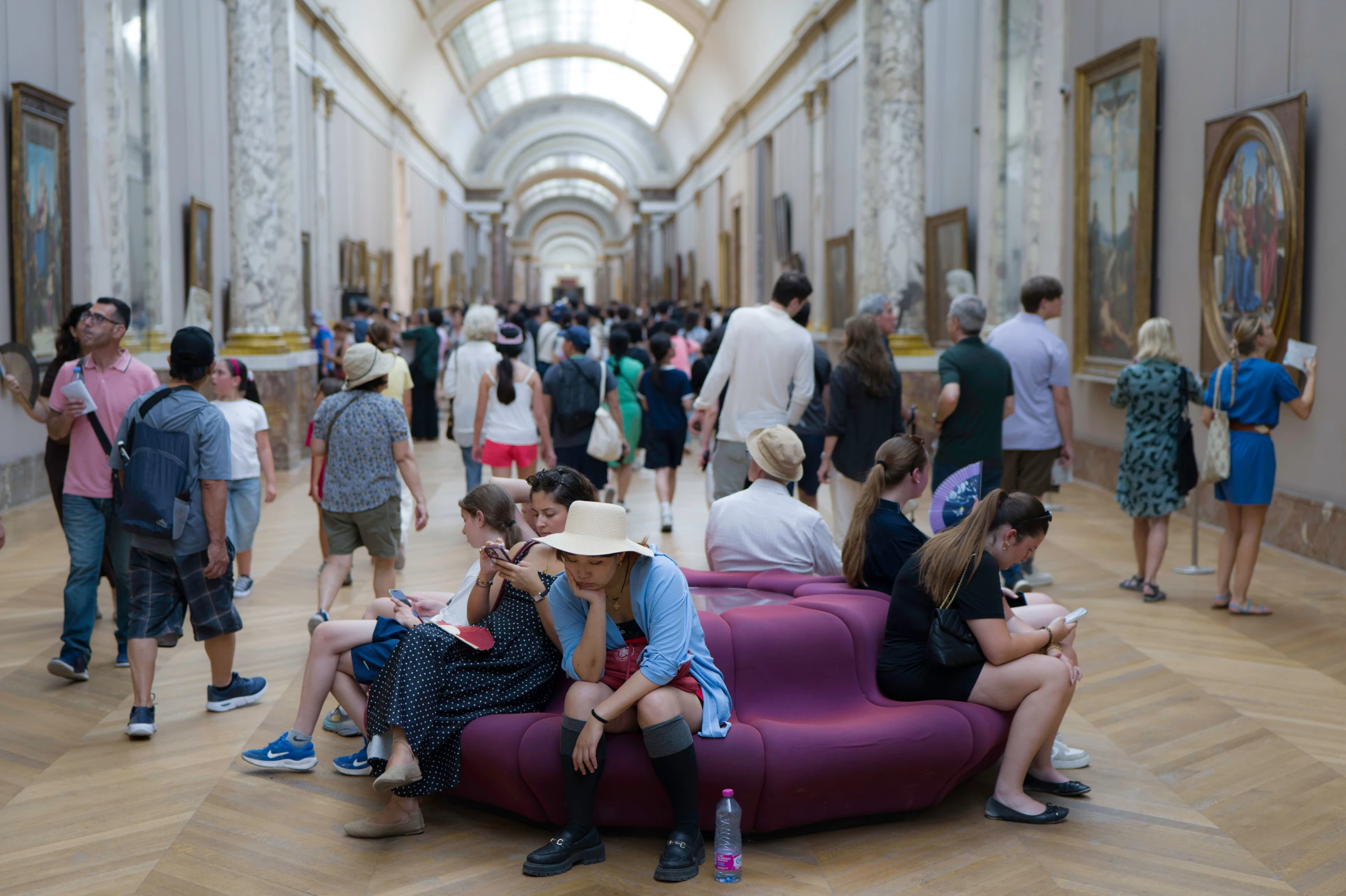 A wide shot of a museum gallery with classical sculptures and artworks