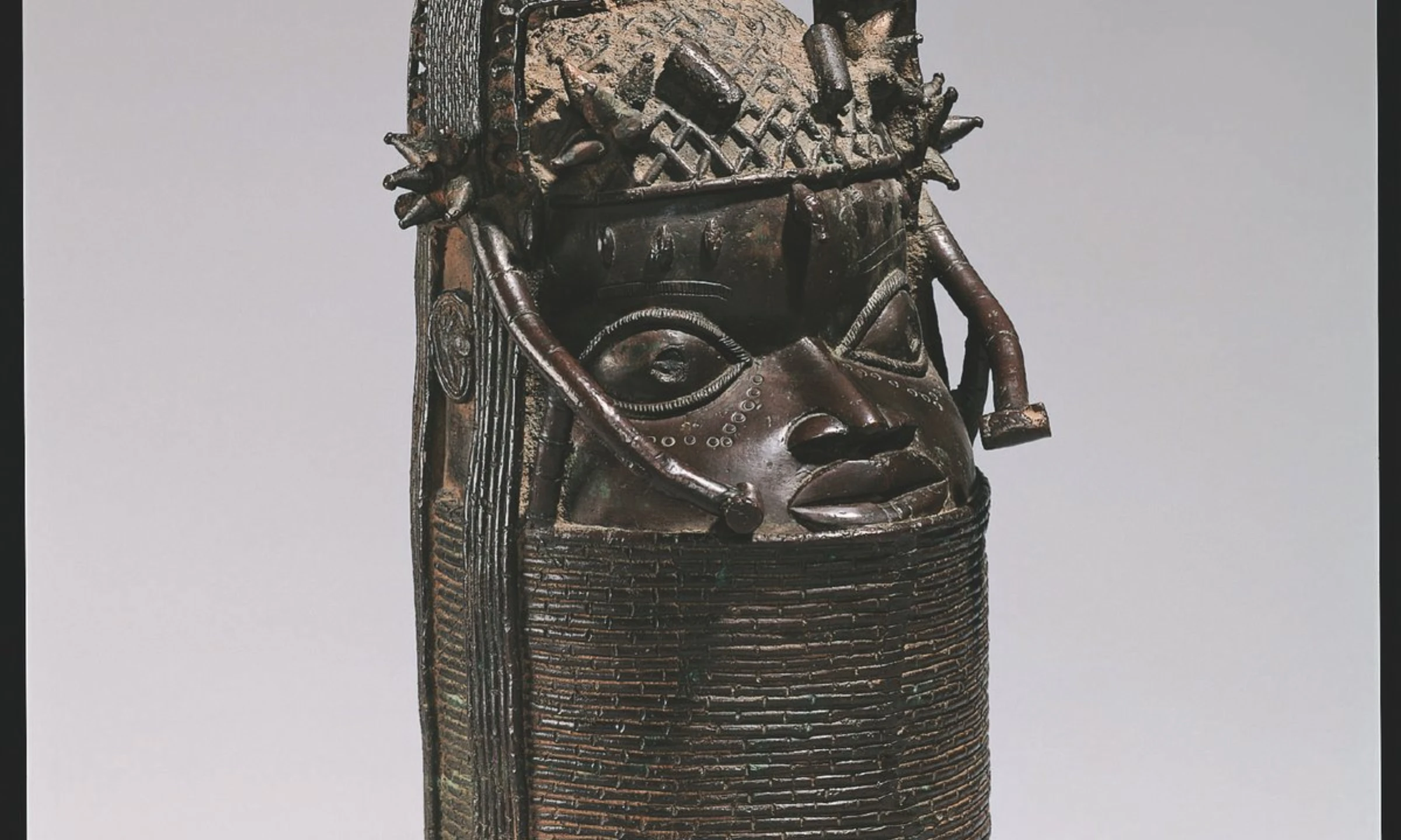 Ivory and bronze Benin court object displayed in museum lighting