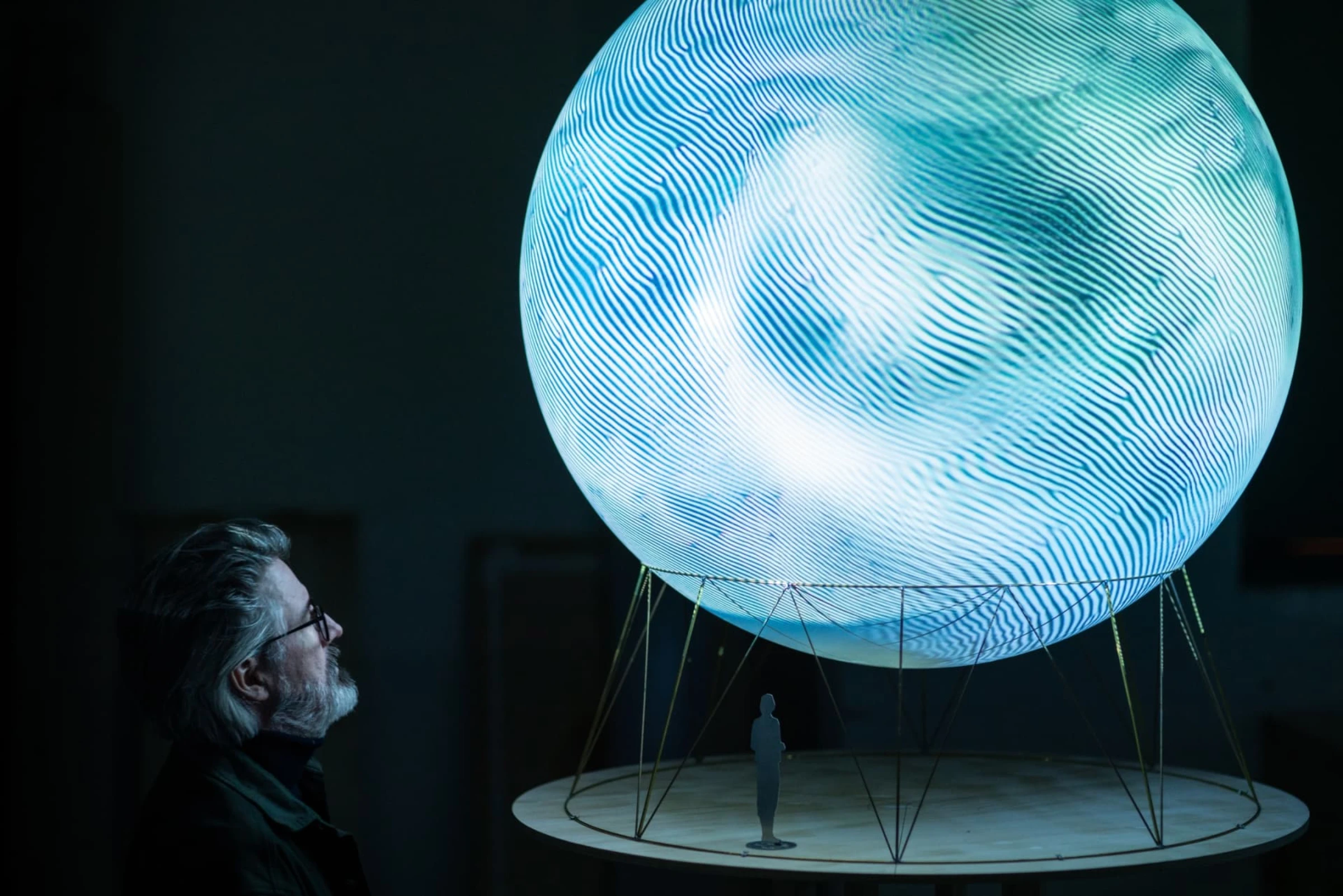 A luminous sphere glows in a city park during Olafur Eliasson’s public artwork for the Great Salt Lake.
