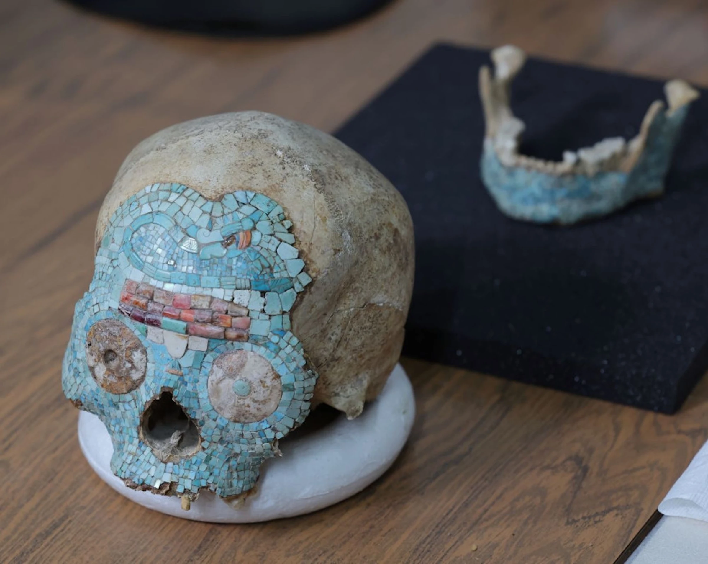 Pre-Hispanic Mixtec human skull adorned with turquoise, shell, jadeite and quartz mosaic, photographed after repatriation to Mexico