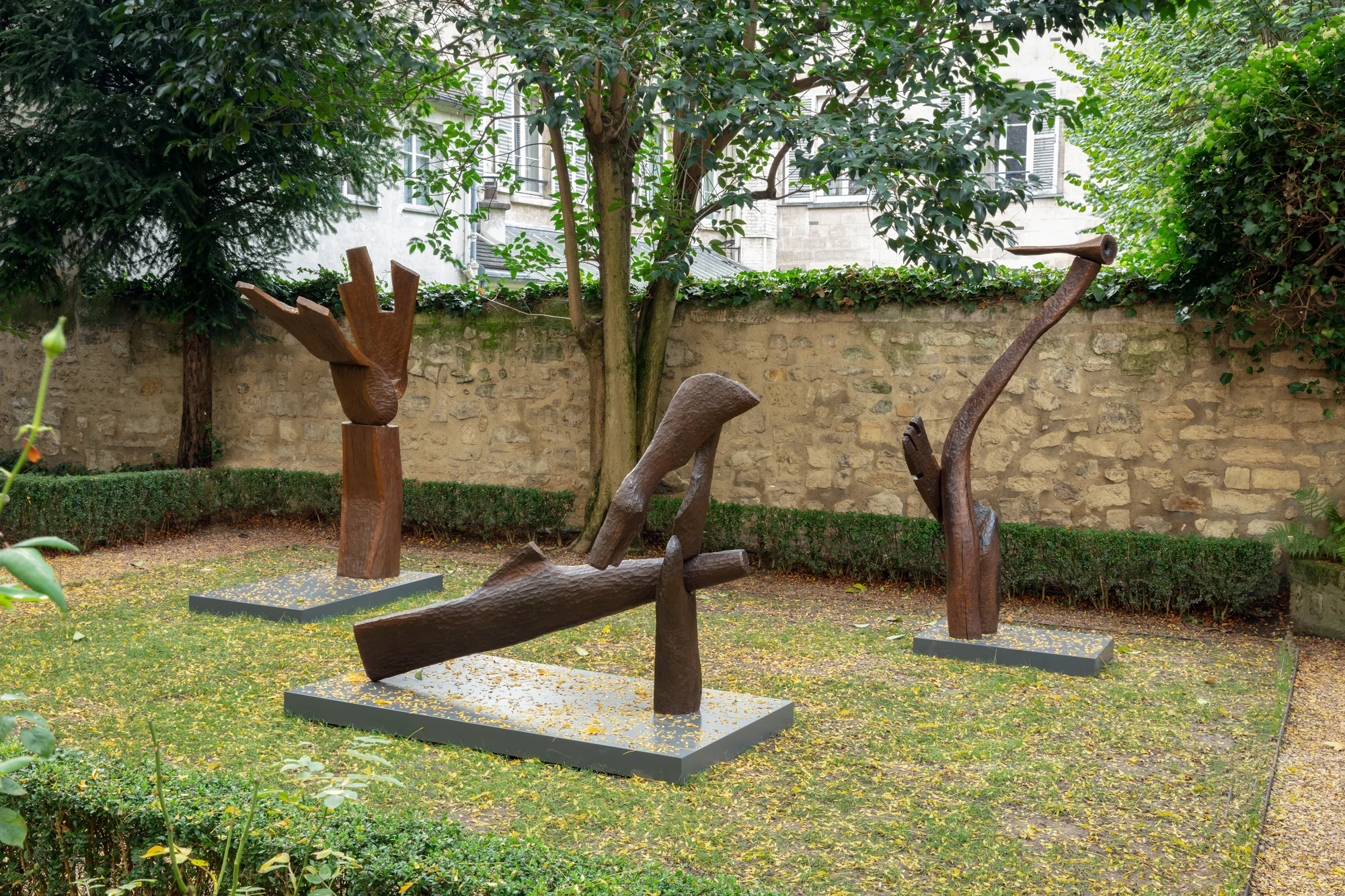 Thaddeus Mosley standing with one of his early wood sculptures in Pittsburgh