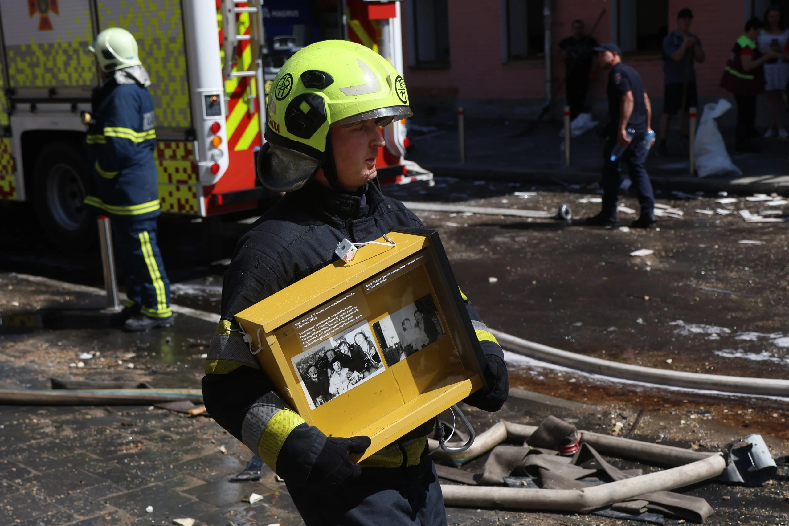 Workers carry rescued objects from the damaged Ukrainian National Chornobyl Museum in Kyiv